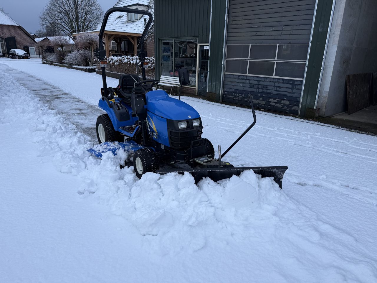 New Holland TZ 24 minitrekker met sneeuwschuif. Sneeuwschuiver