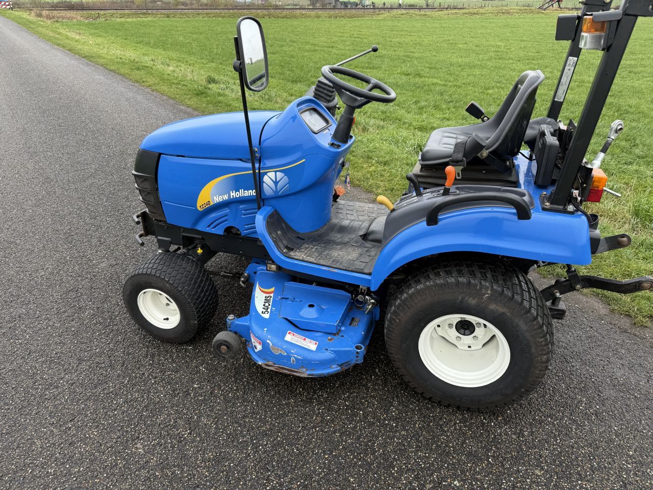 New Holland TZ 24 minitrekker met sneeuwschuif. Sneeuwschuiver