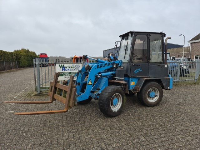 Ahlmann AL7 met palletvorken en kuilhapper.