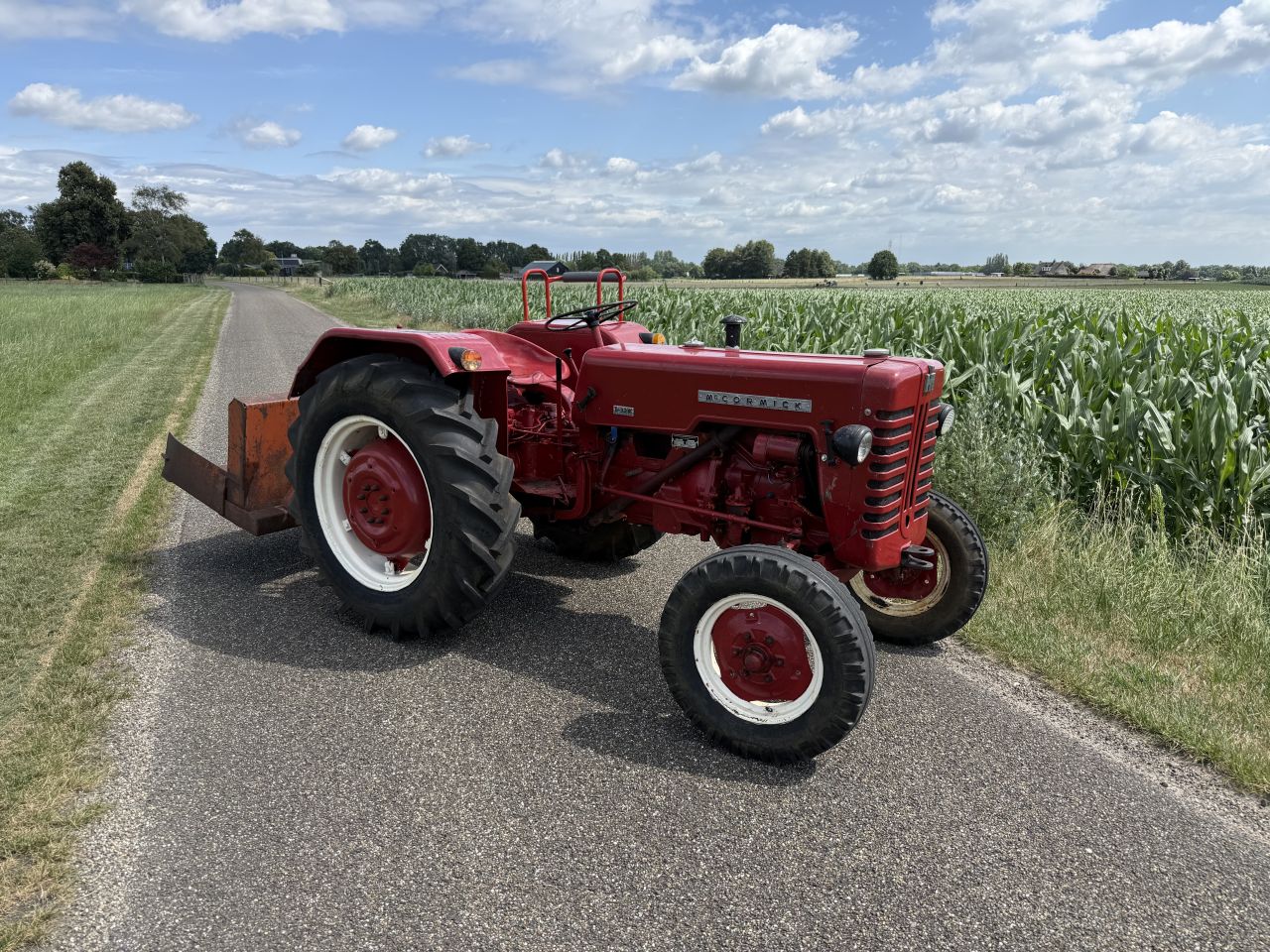 MC Cormick D 324 trekker tractor met grondbak