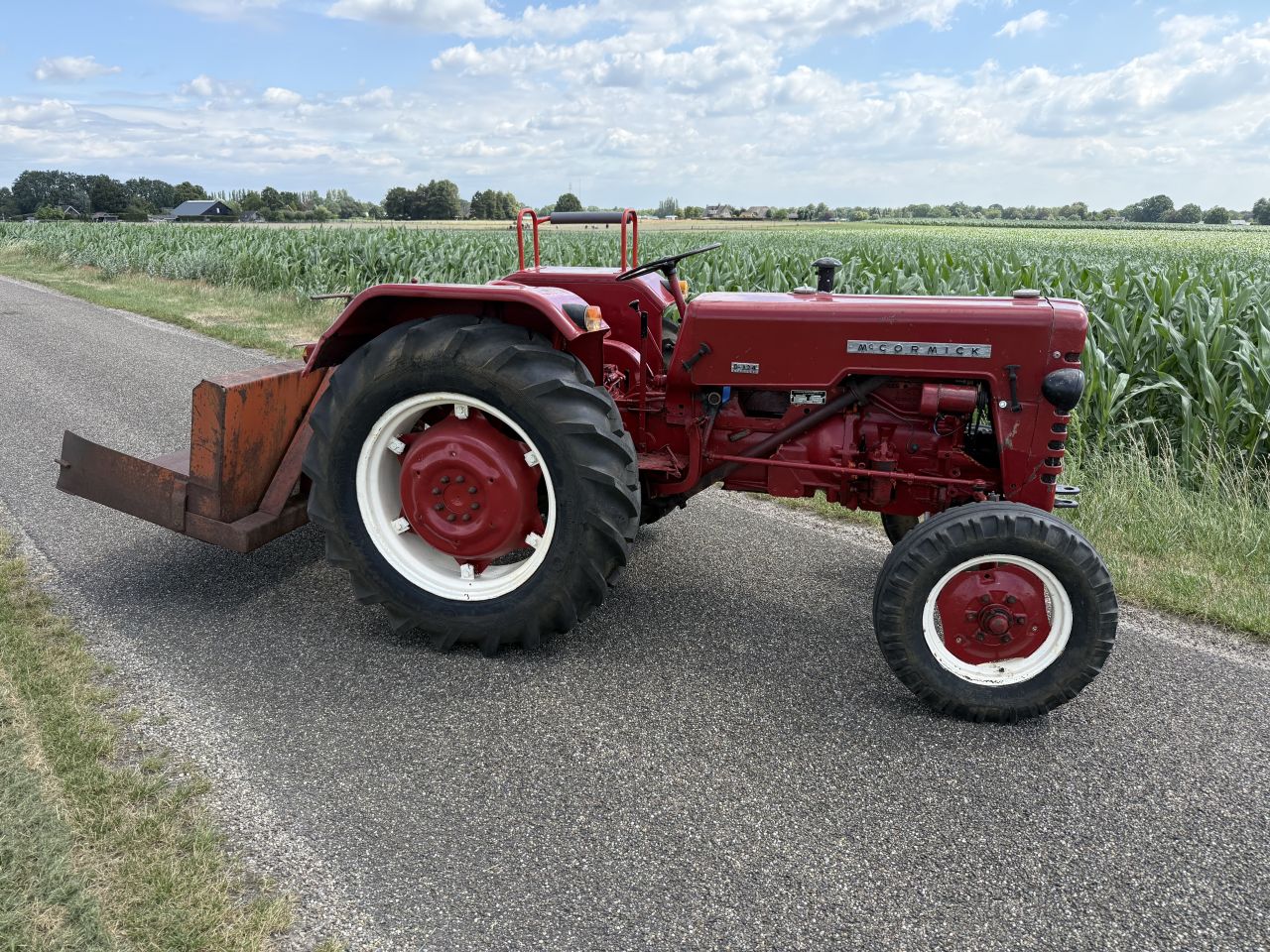 MC Cormick D 324 trekker tractor met grondbak