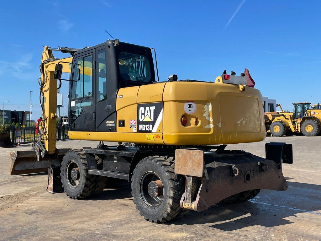 Caterpillar M313D VA - Outriggers + Blade