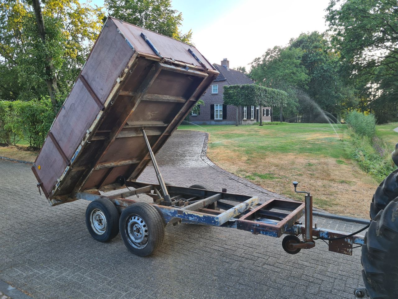 Kieper kiepwagen kiep aanhanger achter trekker.