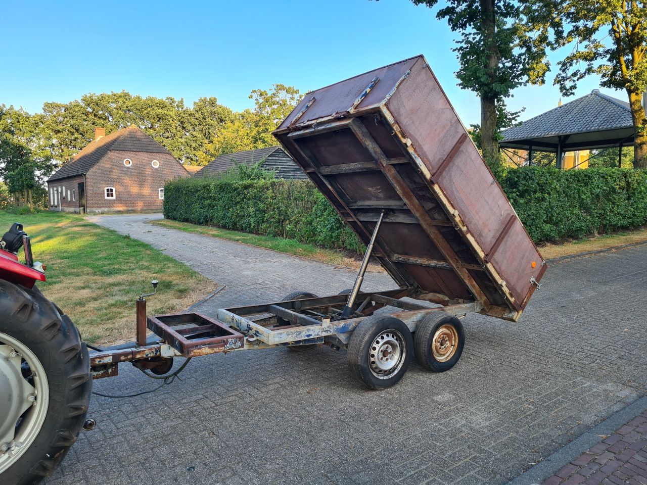 Kieper kiepwagen kiep aanhanger achter trekker.